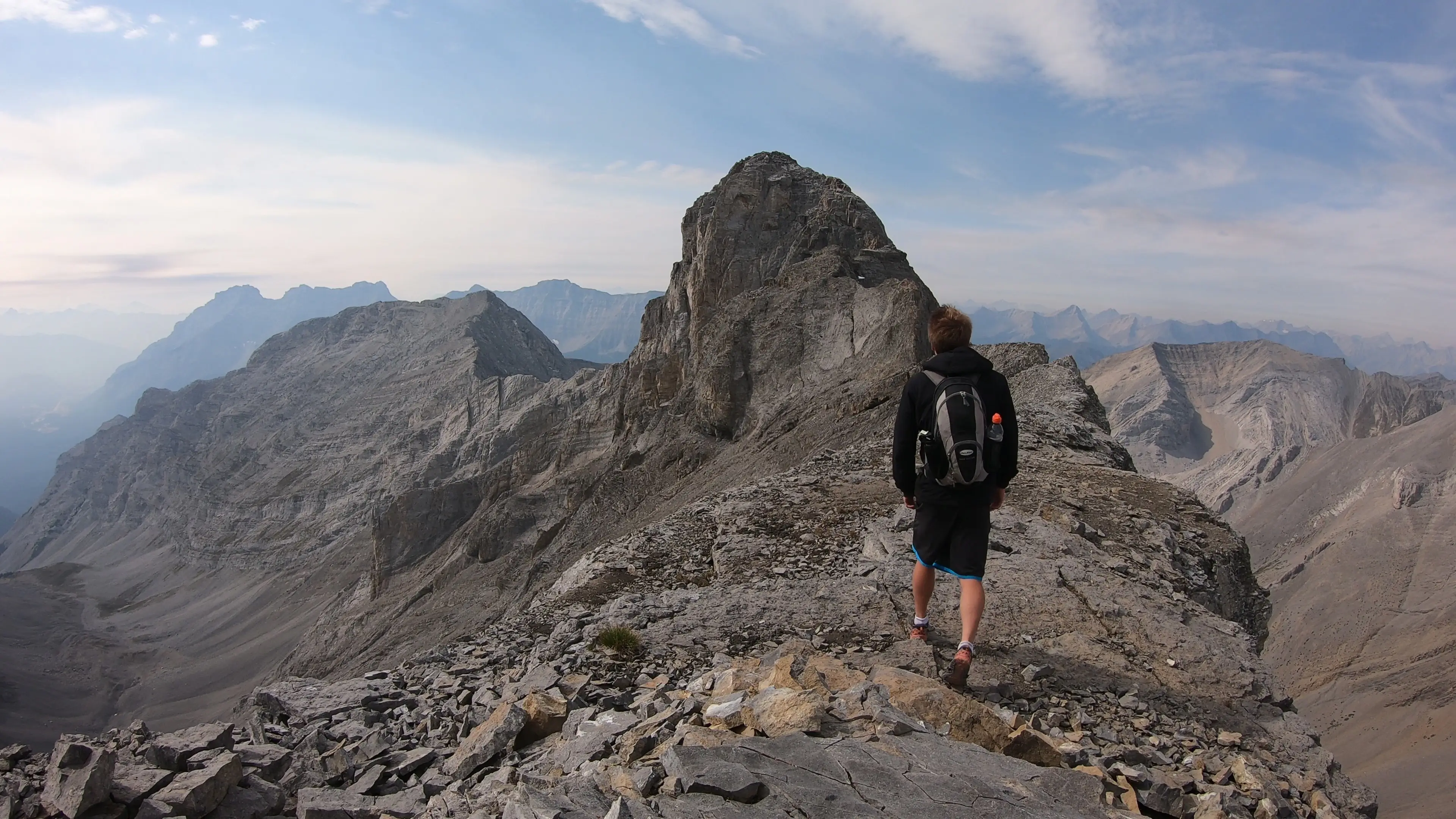 A climber approaching the summit block of Mount Astley from the technical west side during the Astley Traverse.
