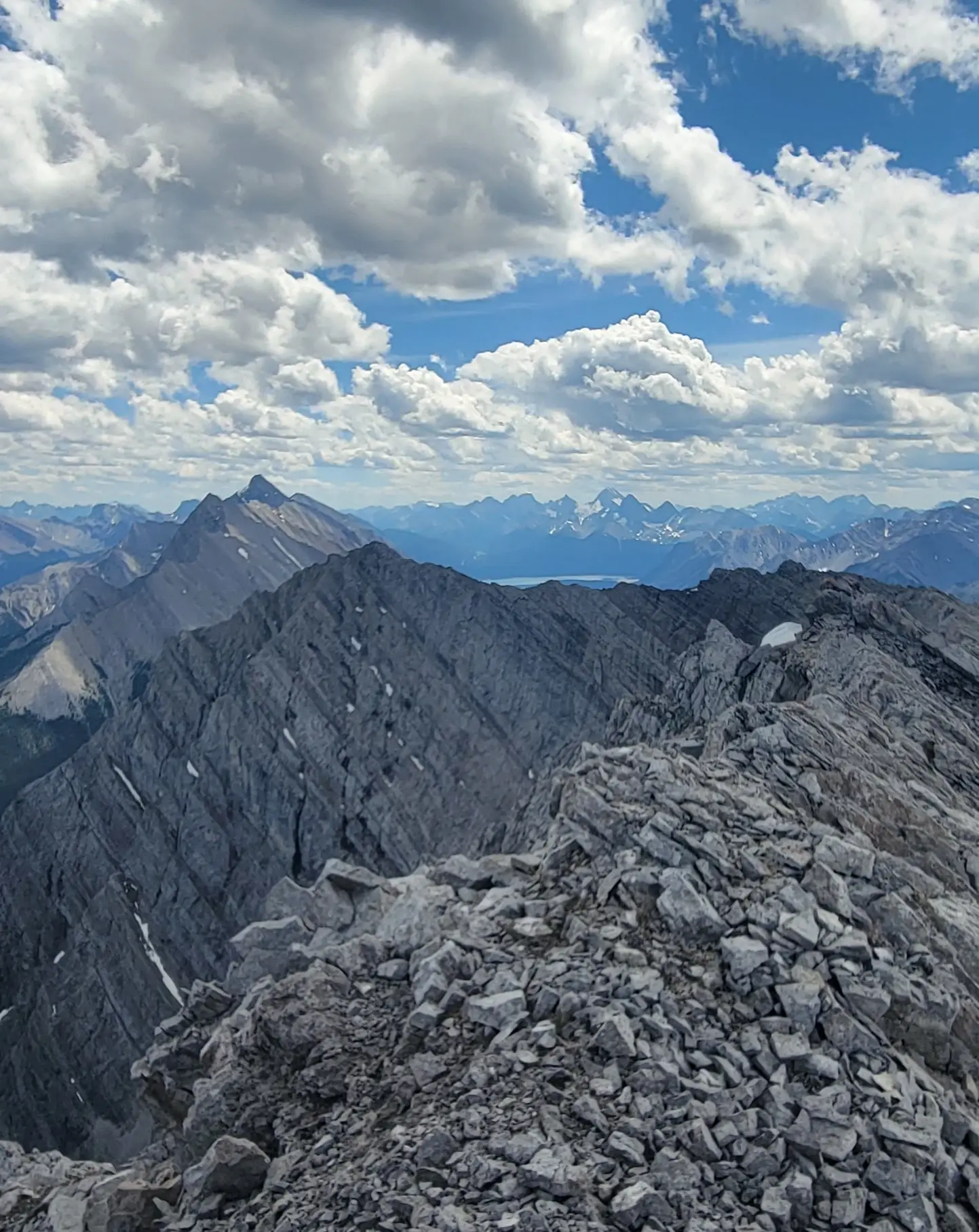 A view looking south from the ridge along the Goatview Peak massif with numerous peaks visible on the horizon.
