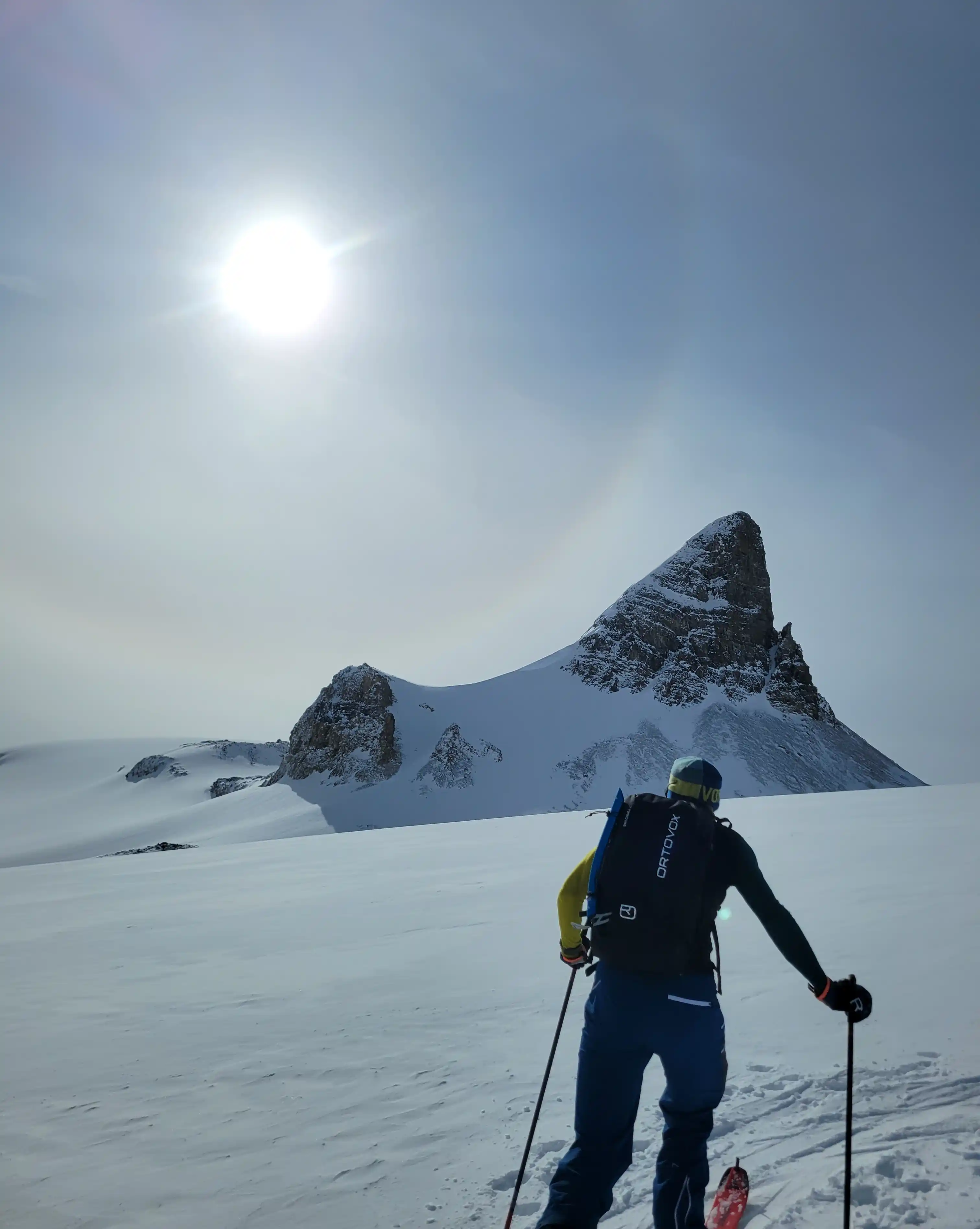 A climber on the south ridge of Mount Vaux with snow on it's east side and a sizable drop to the west.